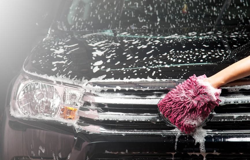someone washing a black car