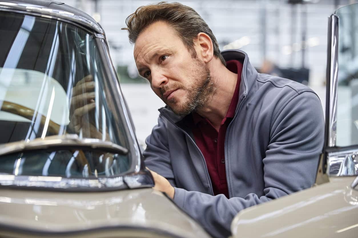 mechanic looking in classic car