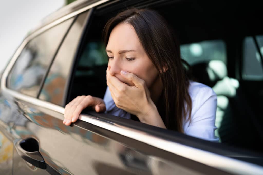 Women hanging head out of window whilst gagging