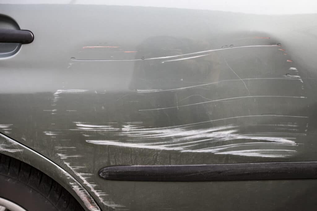 Grey car with a scratched door.